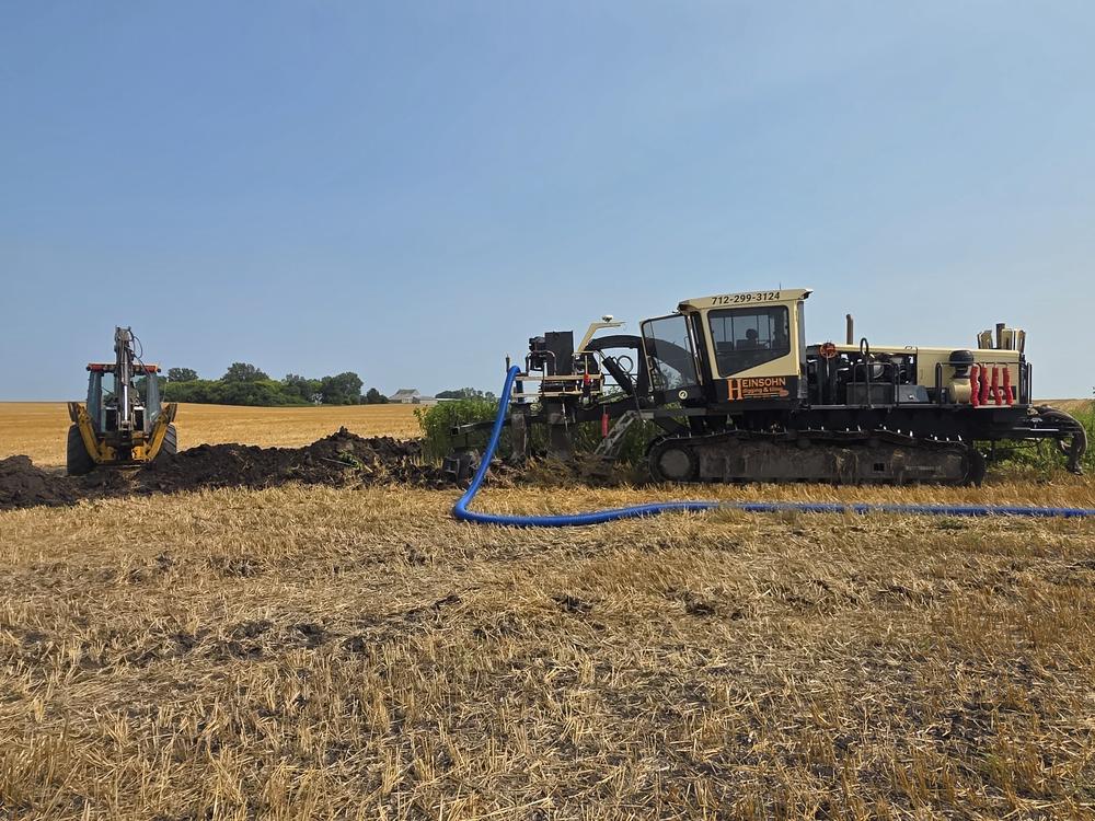 Excavator demolishing an old farm building near Storm Lake, Iowa