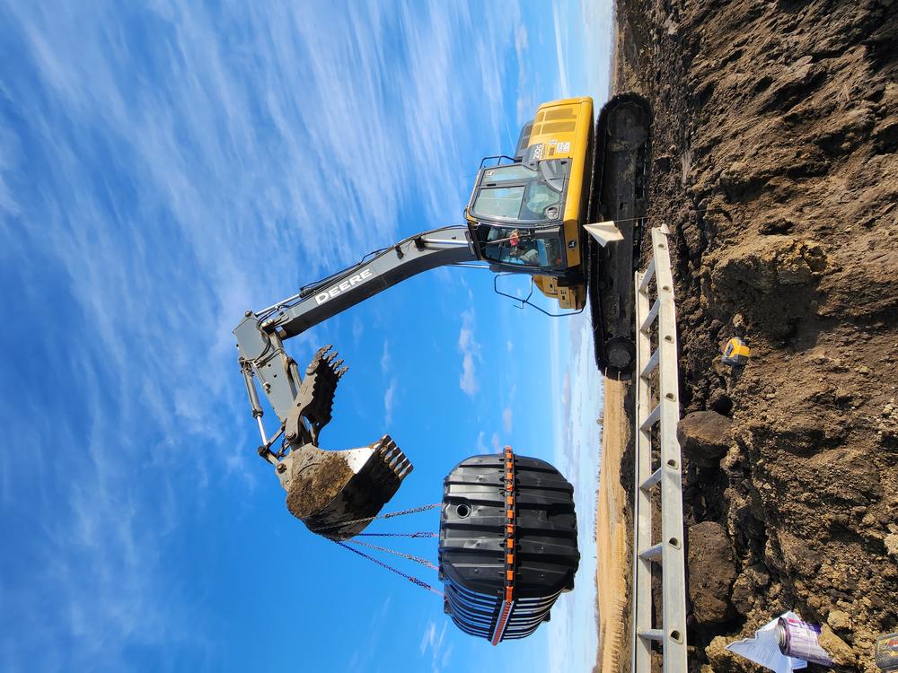 Excavator demolishing an old farm building near Storm Lake, Iowa